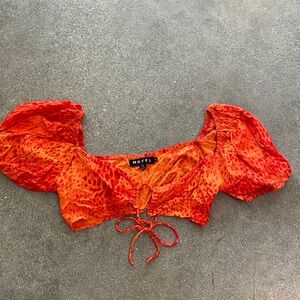 Motel crop top with lace up front detail. Orange red animal print